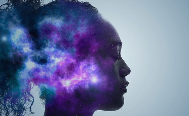 A profile of a woman's face with her eyes closed is blended with an abstract, colorful cosmic nebula, giving the impression that her thoughts are intertwined with the universe.