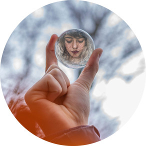 A crystal ball reflecting the face of the girl who is holding the ball